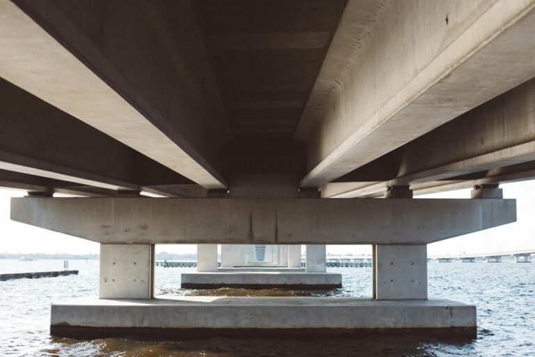 Modern concrete bridge over water, displaying architectural details and symmetry.