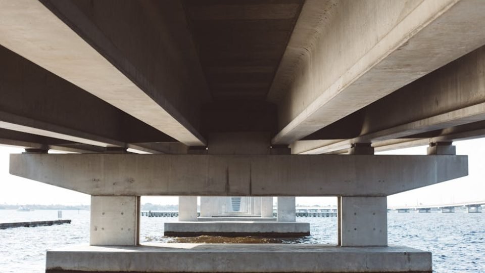 Modern concrete bridge over water, displaying architectural details and symmetry.